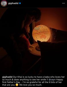 Zayn holding Khai in front of a glowing globe